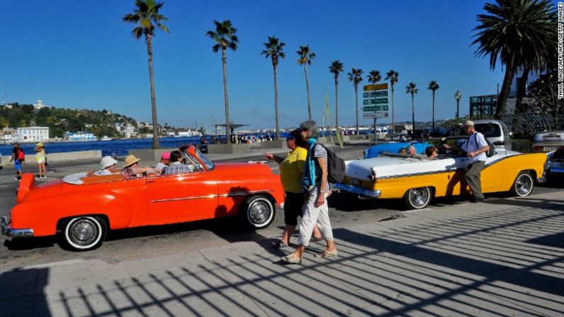 Turistas estadounidenses aprecian los antiguos autos de EE.UU. en La Habana. Cuba se está preparando para acomodar a una afluencia de visitantes.