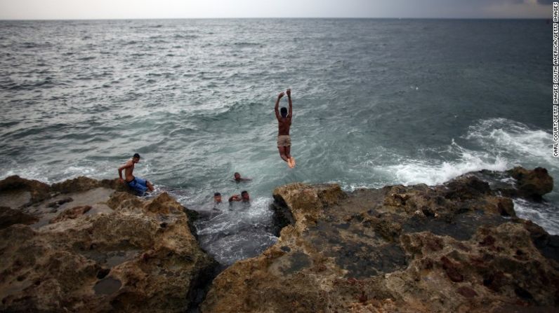 Un grupo de lugareños nadan por el Malecón en el área costera en La Habana.