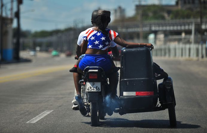 De paseo en moto por La Habana. Una mujer con los colores de la bandera de EE.UU., tan popular en estos días de visita histórica de un presidente estadounidense.