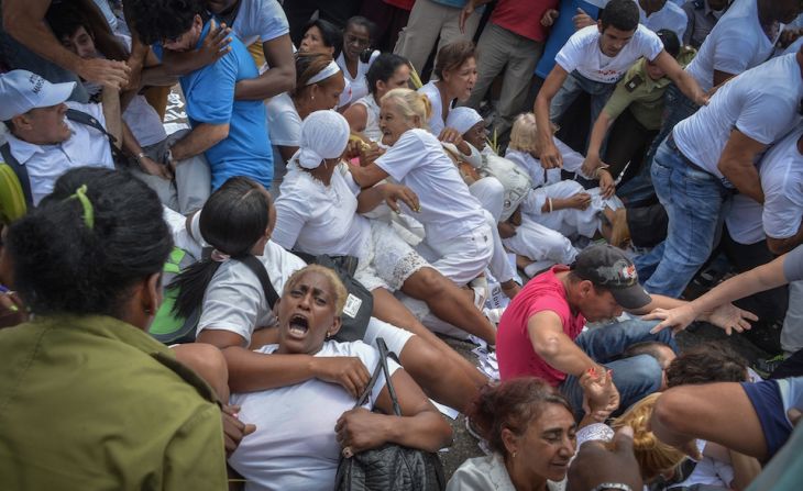 Members of dissident group "Ladies in White", wives of former political prisoners, are detained during their protest on March 20, 2016 in Havana. President Barack Obama flew out of the United States on Sunday bound for a historic three-day visit to the communist-ruled island of Cuba. It is the first visit to Cuba by a sitting US president since Fidel Castro's guerrillas overthrew the US-backed government of Fulgencio Batista in 1959 and the first since President Calvin Coolidge's trip to the island 88 years ago. / AFP / ADALBERTO ROQUE.