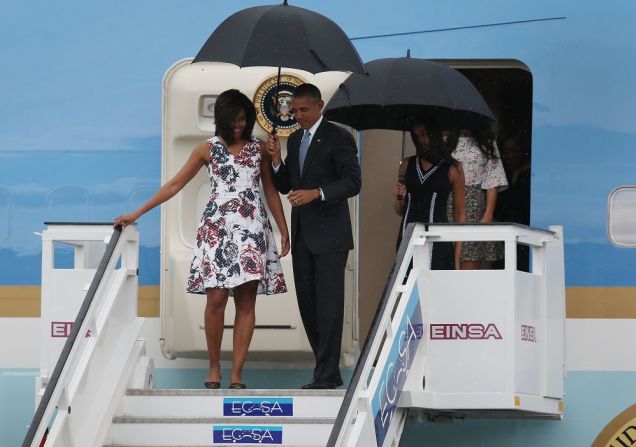 El presidente Barack Obama, acompañado de su esposa Michelle, bajan las escaleras del avión para comenzar la histórica visita de 48 horas a la isla.