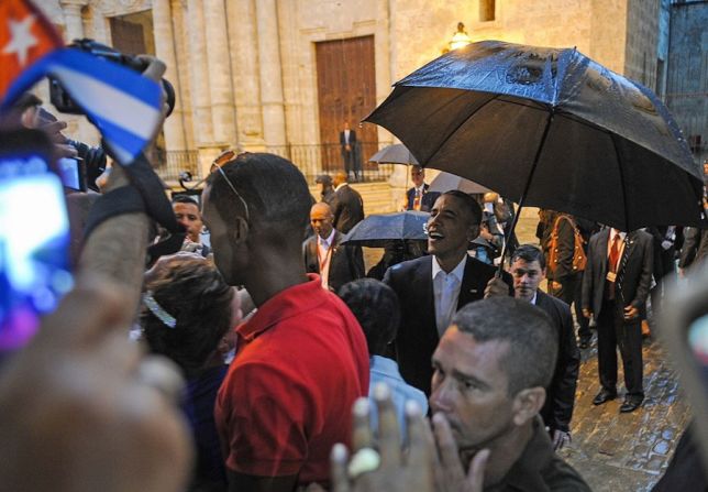 La lluvia y las multitudes de curiosos acompañaron a los Obama durante su paseo (YAMIL LAGE/AFP/Getty Images).