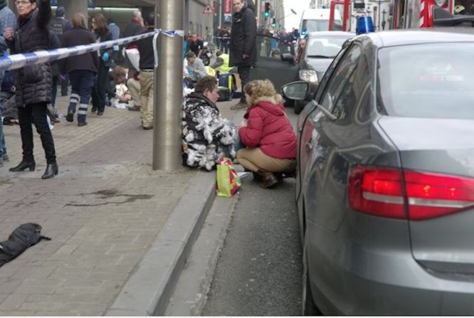 Una mujer asiste a otra cerca al sistema de transporte en el que se registraron explosiones en la mañana del martes en Bruselas, Bélgica.