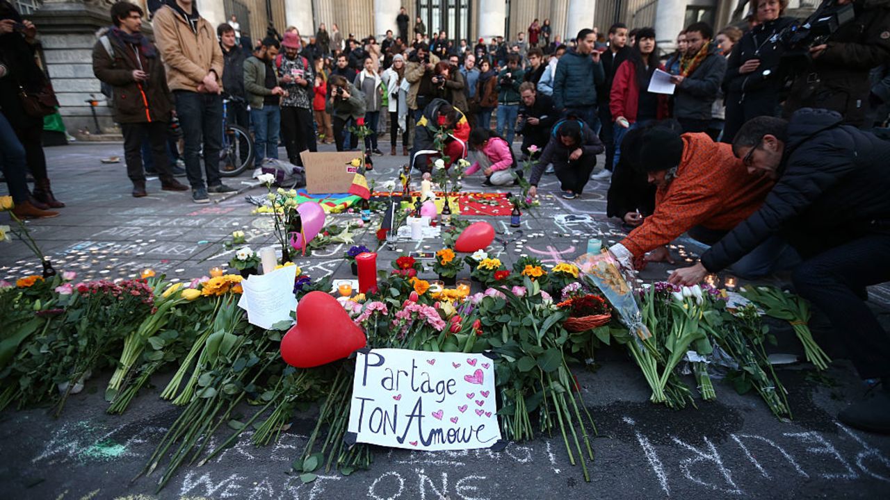 Un grupo de personas se reúnen para rendir tributo a las víctimas de los atentados terroristas de Bruselas.