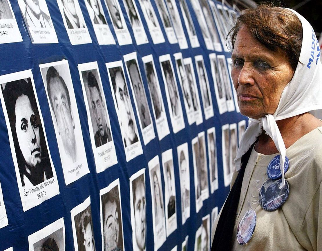 Tati Almeida, integrante de la organización Madres de Plaza de Mayo, (linea fundadora), observa una gran bandera con fotos de desaparecidos durante la última dictadura militar (1976-1983) colgada frente a la Casa de Gobierno en Buenos Aires, Argentina, el 04 de diciembre de 2002 durante la marcha anual de resistencia de 24 horas en la Plaza de Mayo.