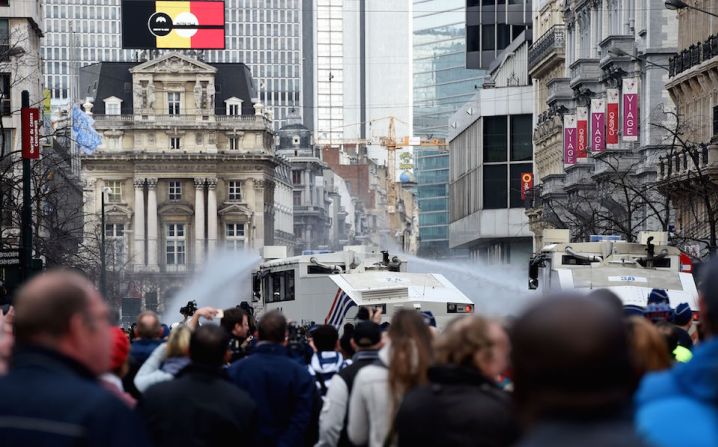 Un hombre enmascarado hace el saludo nazi al irrumpir en un acto de homenaje en a víctimas de los ataques terroristas en Bruselas.