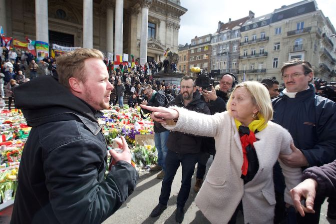 Una mujer reclama airadamente a un hombre que formaba parte del grupo que interrumpió un acto de recuerdo por las víctimas de los ataques terroristas en Bruselas.