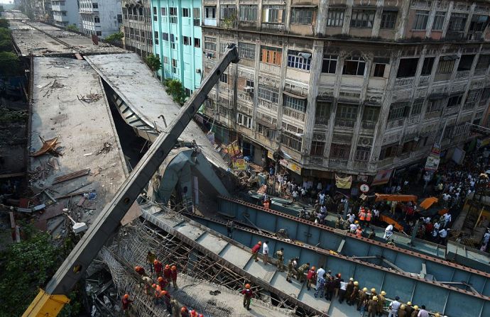 Rescatistas y voluntarios buscan víctimas de la caída de un puente en Kolkata que dejó al menos 15 muertos.