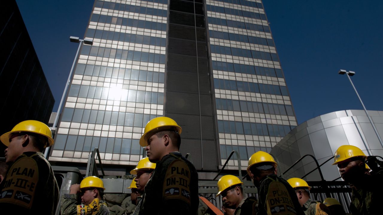 Mexican soldiers arrive at the headquarters of the state-owned Mexican oil giant Pemex, following a blast on the eve, in Mexico City on February 01, 2013. An explosion rocked the skyscraper, leaving up to 32 dead and 121 injured. Hundreds of firefighters, police and soldiers toiled through the night after the blast ripped through an annex of the 54-floor tower leaving concrete, computers and office furniture strewn on the ground.   AFP PHOTO/YURI CORTEZ