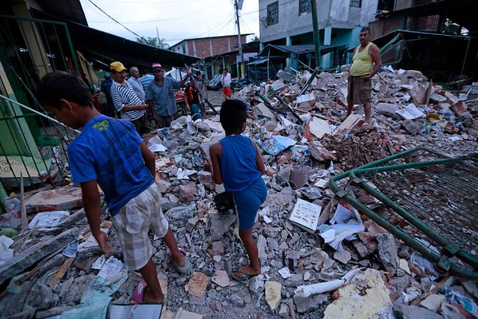 Varias personas remueven, en Manta, los escombros de una edificación derruida por el terremoto que sacudió Ecuador.