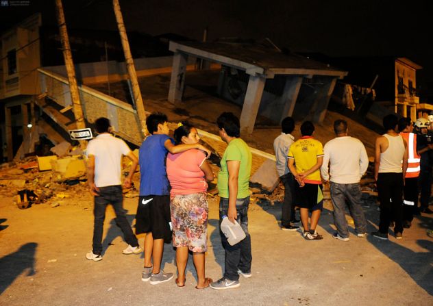 Un grupo de personas reunido en torno a una edificación derruida por el terremoto de Ecuador.