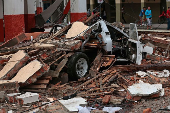 Un vehículo quedó completamente destrozado por los escombros de las edificaciones que cayeron en Portoviejo, Ecuador, tras el terremoto del sábado.