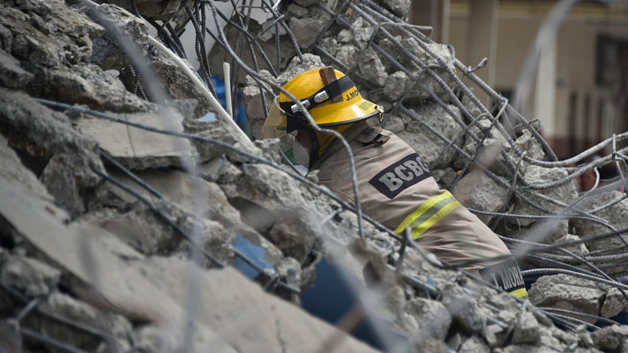 Un bombero busca supervivientes entre los escombros de un edificio de Guayaquil que derribó el terremoto de 7,8.