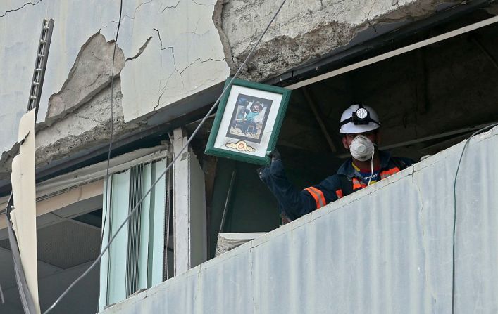 Un socorrista muestra una foto encontrada dentro de un edificio destruido en Portoviejo, el 21 de abril.