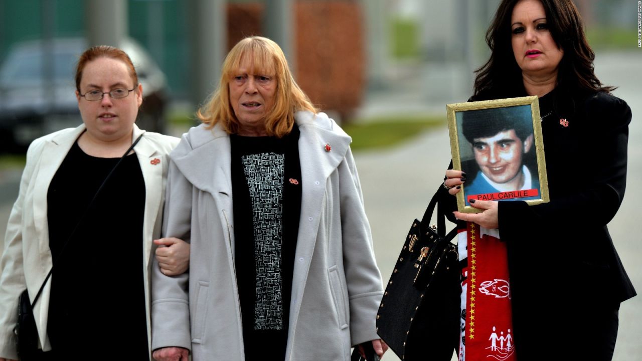 Familiares de las víctimas de la tragedia de Hillsborough muestran la foto de Keith McGrath, una de las personas fallecidas. Crédito: AFP PHOTO / PAUL ELLIS.