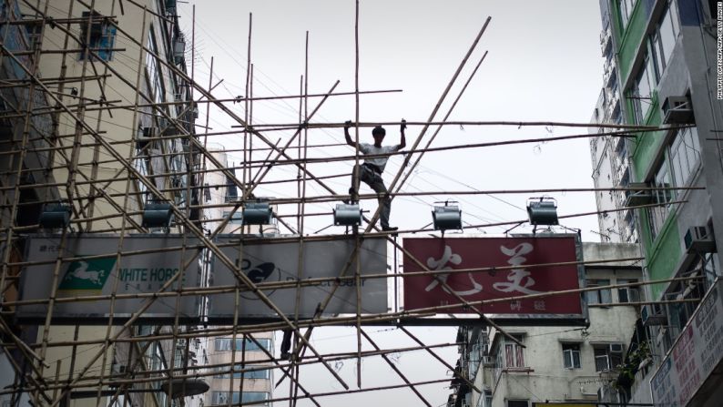 Los trabajadores usan una técnica llamada 'cabalgando el bambú', en la que mantienes un tobillo bloqueado alrededor de un palo de bambú, permitiendo que sus manos estén libres.