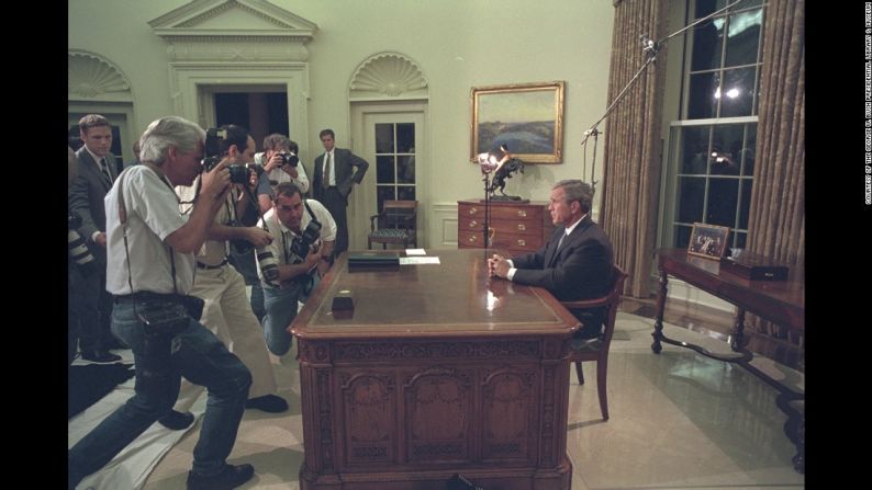 Miembros de la prensa le toman fotografías al presidente Bush antes de dirigirse a la nación desde la Oficina Oval.
