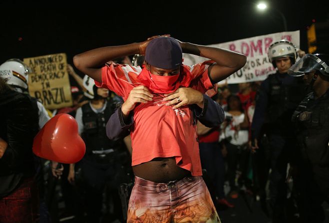 La policía requisa a un manifestante que está en contra del juicio político contra Rousseff en Brasilia luego de enfrentamientos entre los protestantes.