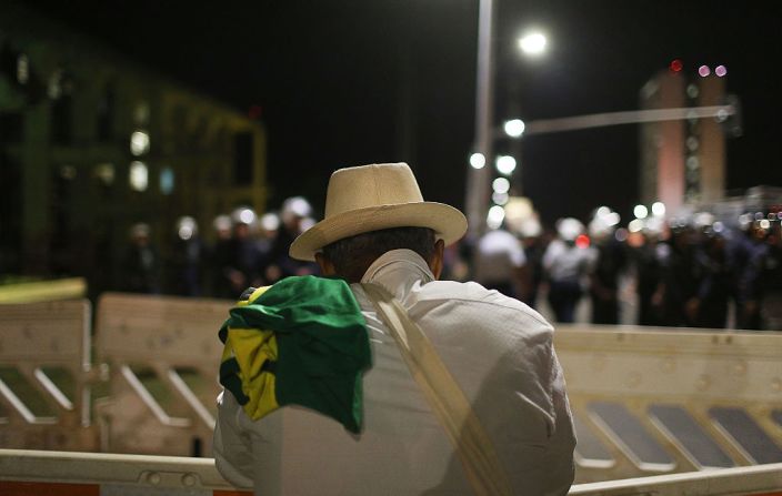 Un protestante progobierno lleva la bandera de Brasil en sus hombros durante las marchas a favor de la presidenta Rousseff la noche del 11 de mayo mientras miembros del Senado decidían si abrir juicio político contra la presidenta.