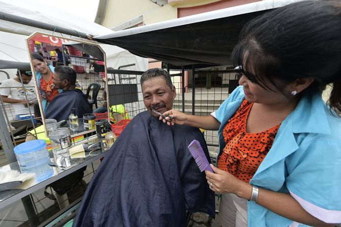 Una estilista le corta el pelo a un hombre en la calle de Pedernales, una localidad que registró el mayor número de víctimas al igual que en la ciudad de Manta.