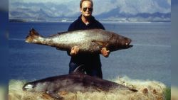 Imagen de 1992 de un pescador sosteniendo un totoaba, también en riesgo de extinción. Sobre la paja se ve una vaquita muerta.