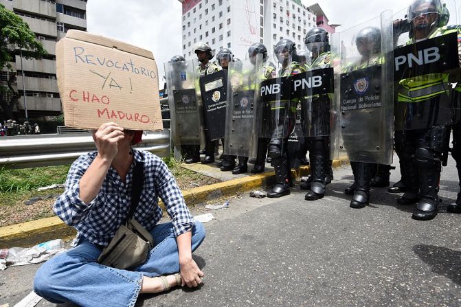 "Revocatorio ya. Fuera Maduro", dice un manifestante sentado frente a funcionarios de la GNB.