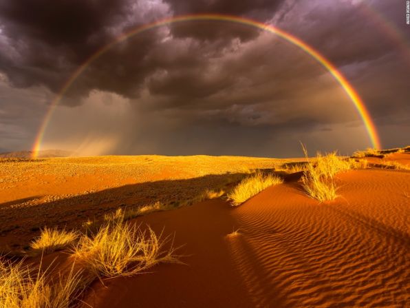 Lluvia en el desierto (Namibia) — El concurso anual de fotografías de viajes de National Geographic ha recolectado algunas imágenes impresionantes como esta de una rara tormenta eléctrica y un arco iris en el Namibrand-Park en Namibia que tomó Stefan Foster.