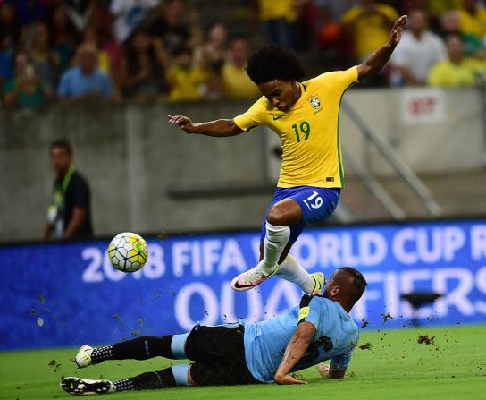 Willian, centrocampista, es visto en esta imagen saltando sobre el uruguayo Álvaro Pereira durante un partido de clasificación para el Mundial de Rusia 2018 el pasado 25 de marzo de 2016. Dunga tiene las esperanzas puestas en Willian quien jugó en la Copa América de Chile 2015 y fue incluido en el Once Ideal de la primera fecha de ese torneo.