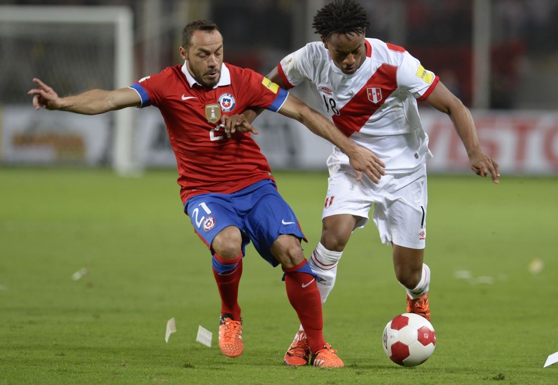 Marcelo Díaz (izquierda) y André Carrillo, de Perú, disputan el balón durante su partido de clasificación para el Mundial 2018 en el estadio Estadio Nacional de Lima, el 13 de octubre de 2015. Crédito: ERNESTO BENAVIDES / AFP / Getty Images.