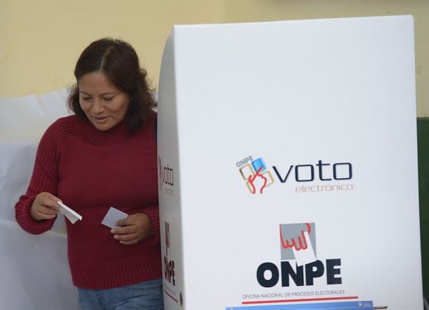 Una mujer sale del cubículo en el cual emitió su voto en las eleciones presidenciales de Perú.