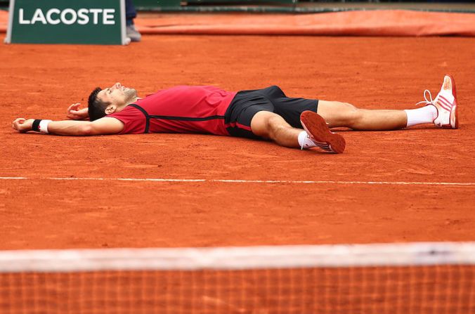 Acostado en la arcilla sobre la cual nunca había ganado, el tenista Novak Djokovic celebra su triunfo en el Roland Garros.