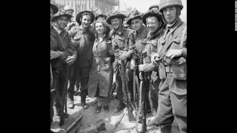 Las tropas británicas posan para una fotografía con una mujer sa en La Breche d'Hermanville.