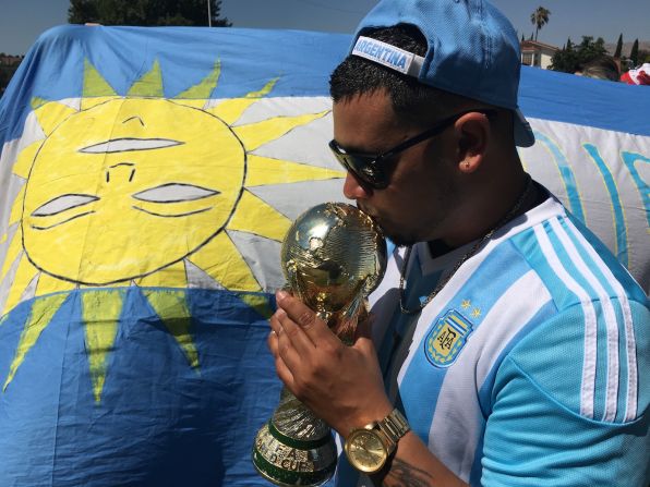 Un fanático besando una Copa del Mundo.