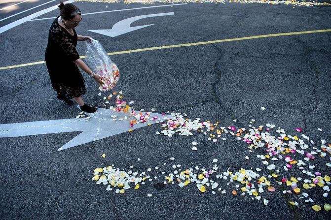 Una mujer riega pétalos de flores en la calle que recorrerá la procesión fúnebre de Muhammad Ali.