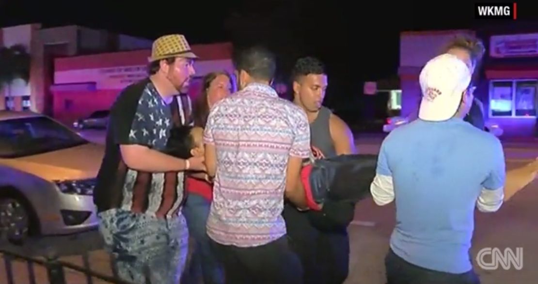 Una mujer es asistida por varios jóvenes tras el tiroteo en la discoteca Pulse de Orlando.