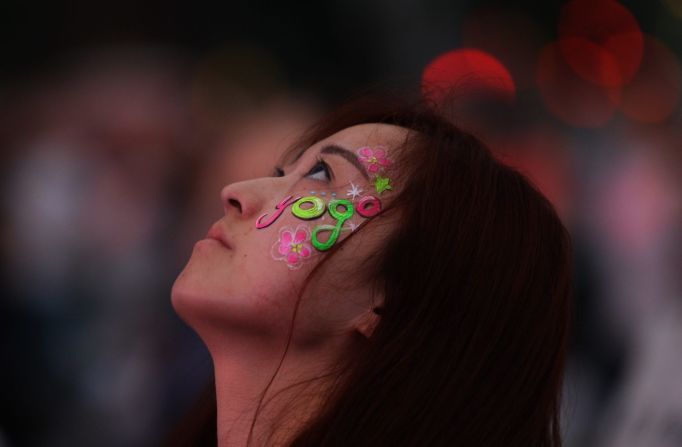 Una mujer surcoreana muestra, con una pintura en su cara, su amor por el yoga.