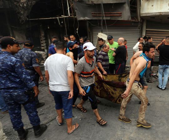 Residentes del barrio de Karrada trasladan el cuerpo de una las víctimas del ataque con camión bomba en la capital de Iraq.