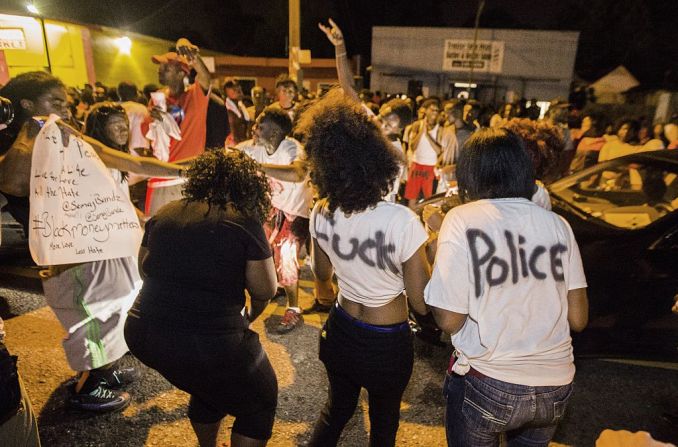 Los manifestantes bailan en la calle donde está ubicada la Triple S Food Mart.