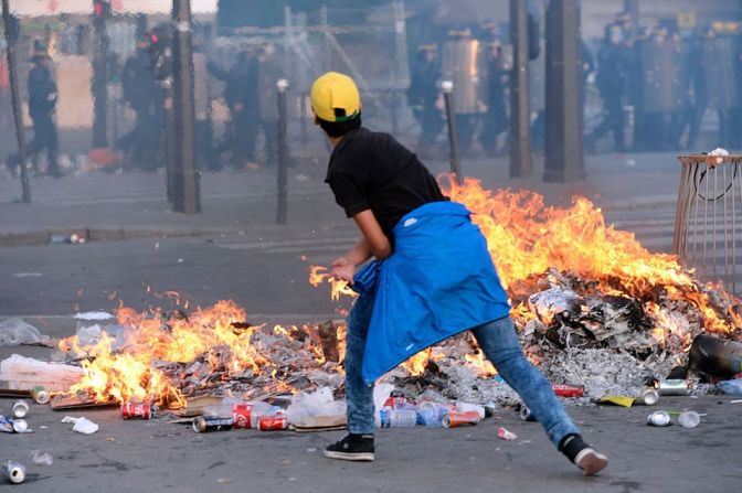 Un aficionado tira objetos a los agentes durante los choques con los policías en la 'fan zone'.