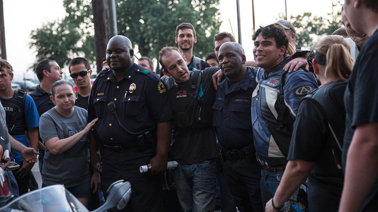 A group of Dallas-area bikers pose for a photo with police officers at the Police Headquarters memorial for officers killed in the recent sniper attack in Dallas, Texas on July 10, 2016.
The gunman who opened fire on Dallas officers during a protest against US police brutality, leaving five dead and seven others wounded, told negotiators he wanted to kill white cops, the city's police chief said July 8. / AFP / Laura Buckman