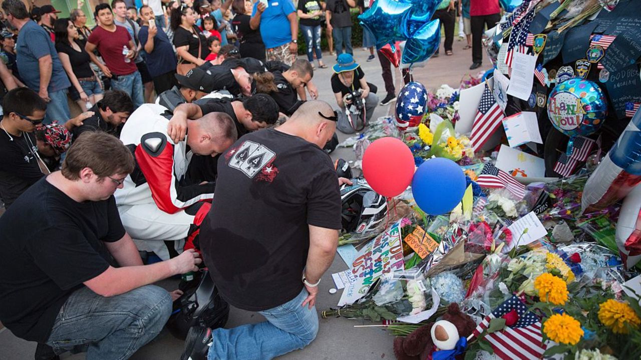 Mourners visit the Police Headquarters memorial for officers killed in the recent sniper attack in Dallas, Texas on July 10, 2016.
The gunman who opened fire on Dallas officers during a protest against US police brutality, leaving five dead and seven others wounded, told negotiators he wanted to kill white cops, the city's police chief said July 8. / AFP / Laura Buckman