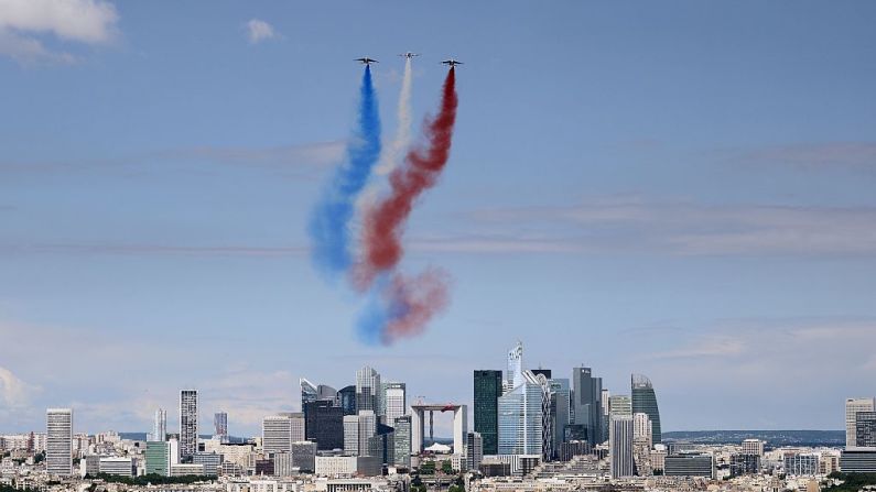 Aviones Alphajet y un Extra EA 300 del grupo acrobático élite Patrouille de France sobrevuelan el distrito financiero de La Defensa en los Campos Elíseos.