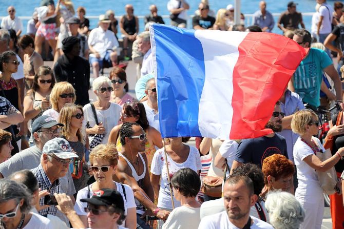 Un hombre sostiene una bandera de Francia durante el tributo a las víctimas este lunes 18 de junio.