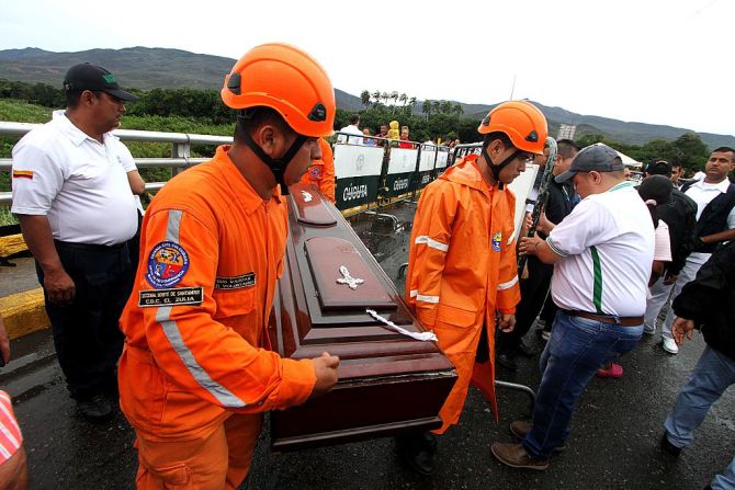 Miembros de la Defensa Civil de Colombia cargan un ataúd vacío en el Puente Simón Bolívar que conecta Venezuela y Colombia.