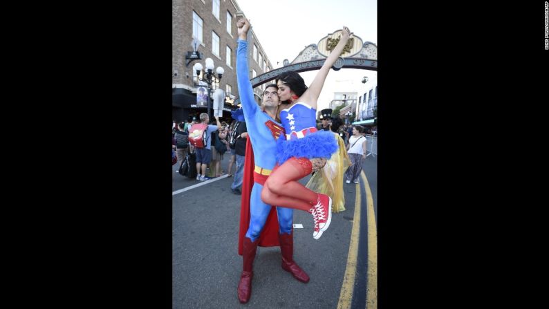 Sergio Valente, disfrazado como Superman, levanta a Jessica Randal, vestida como Vixen, mientras ella lo besa.