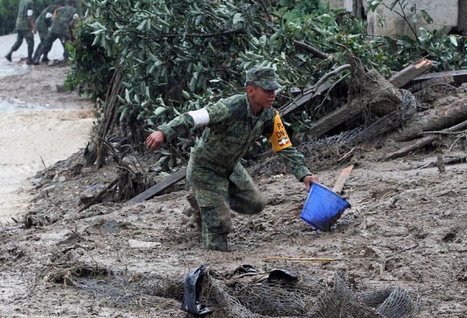 Soldados mexicanos ayudan en las labores de limpieza en una comunidad de Tlaola, en Puebla, uno de los más afectados por las lluvias que dejó la tormenta Earl (JUAN CARLOS SANCHEZ/AFP/Getty Images).