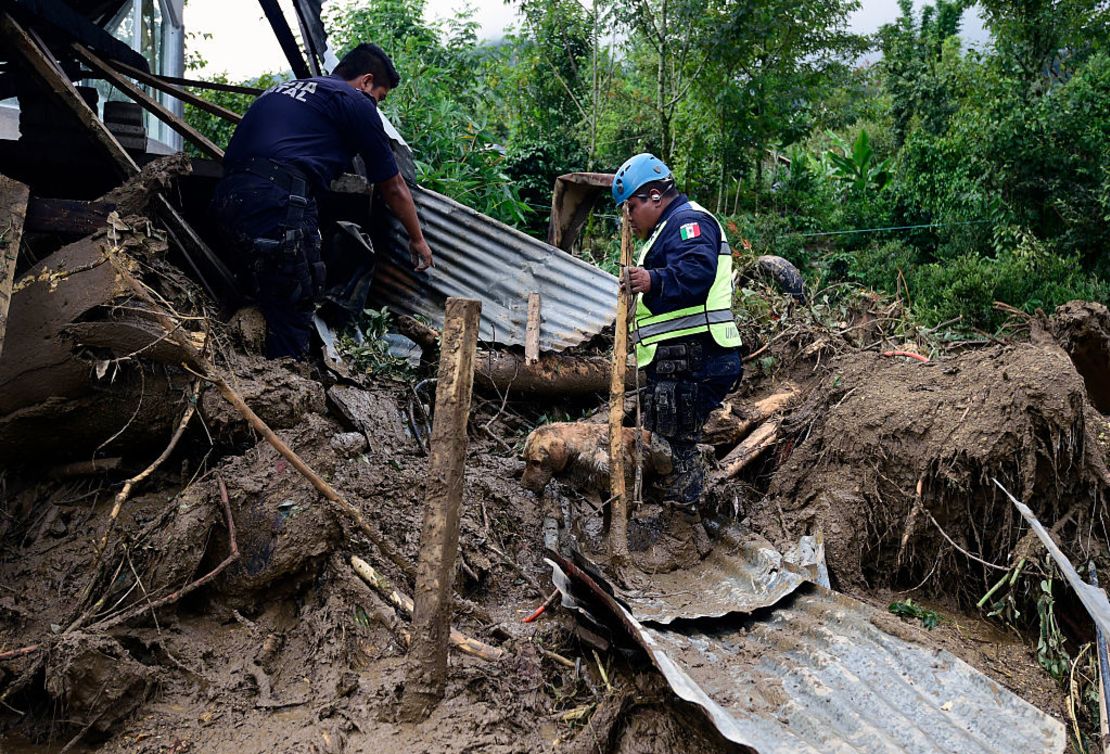 Un policía federal rescatista y su perro buscan cuerpos sepultados en Xaltepec, Puebla, tras la devastación que dejó Earl.