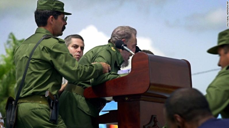 Castro es ayudado después de que al parecer se desmayó después de dos horas de discurso en Cotorro, Cuba, en junio de 2001. Regresó al podio 10 minutos después y le aseguró a su audiencia que estaba bien y sólo necesitaba dormir.