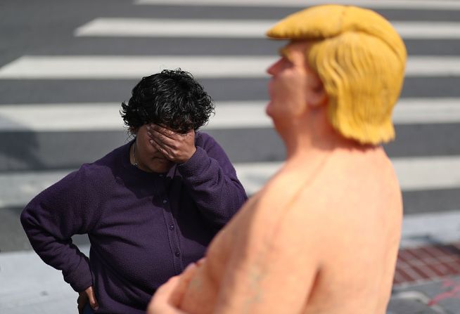 Una transeúnte mira una estatua de Donald Trump instalada en San Francisco por el colectivo de arte INDECLINE que creó cinco estatuas del candidato republicano y las instaló en cinco ciudades este jueves 18 de agosto.