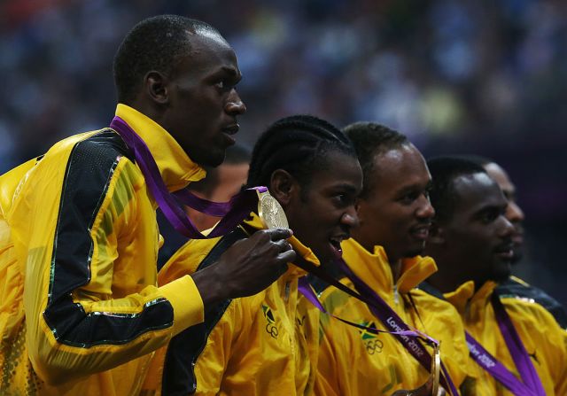 Bolt posa con Michael Frater, Usain Bolt y Yohan Blake mostrando el oro de 4 x 100m en Londres 2012.